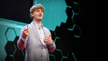 Recursive CEO Richard Socher speaking on stage at a TED conference.